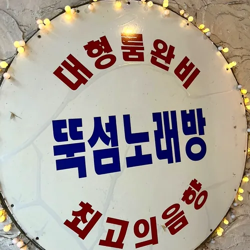 전구로 둘러싼 동그란 간판: 대형룸완비 뚝섬노래방 최고의음향
